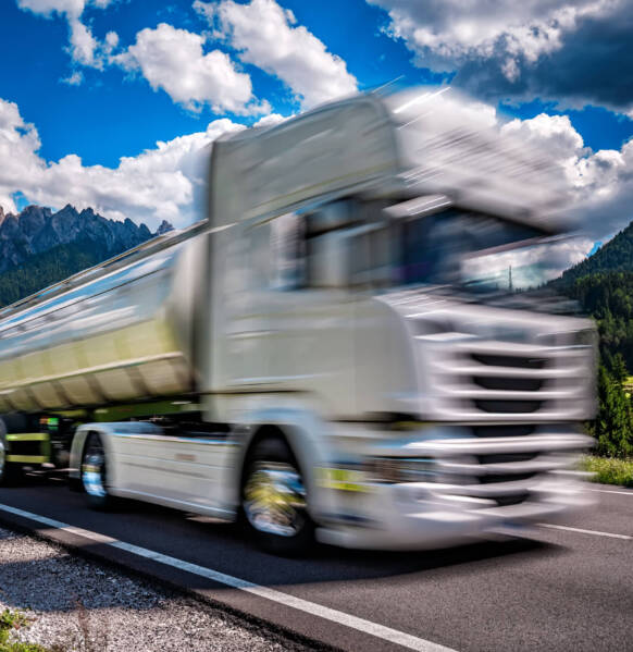 Fuel truck rushes down the highway in the background the Alps. Truck Car in motion blur.